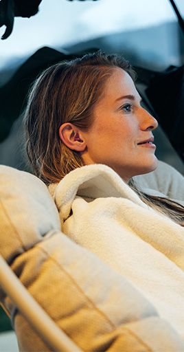 Person wearing custom water protection earplugs while relaxing in a wellness setting. Custom-fit water protection helps keep sensitive ears dry and comfortable by preventing water from entering the ear canal, making it ideal for wellness treatments, bathing, swimming, and everyday water-related activities.
