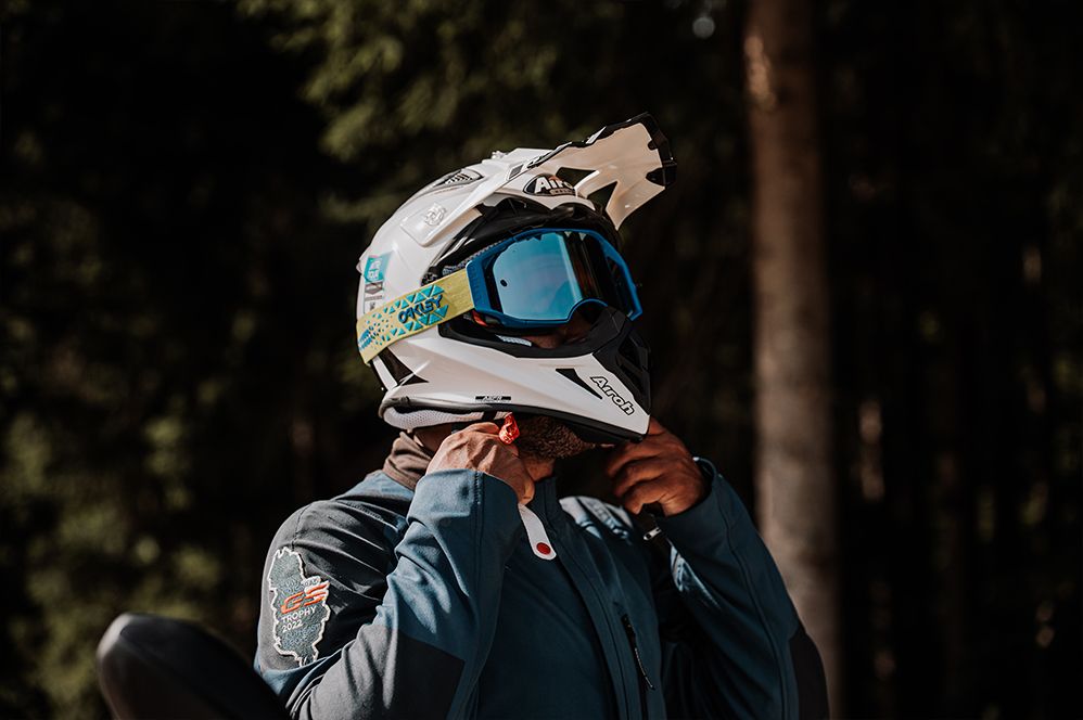 Motorcyclist securing his off-road helmet before a ride – comfort and protection with bachmaier customfit hearing protection.