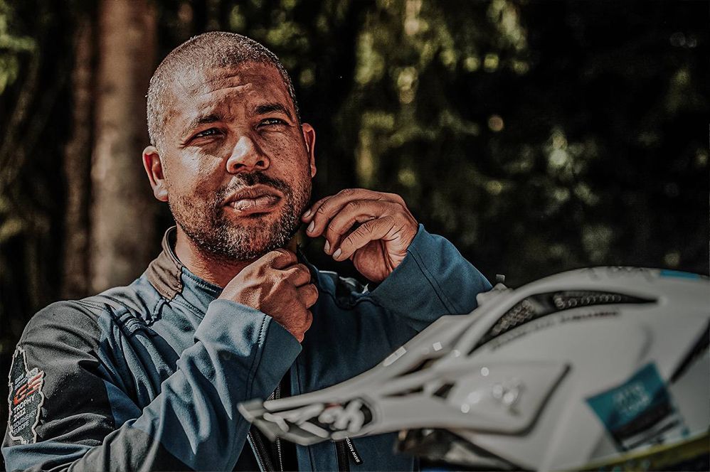 Man adjusting his helmet before a motorbike ride – preparing with bachmaier customfit hearing protection.